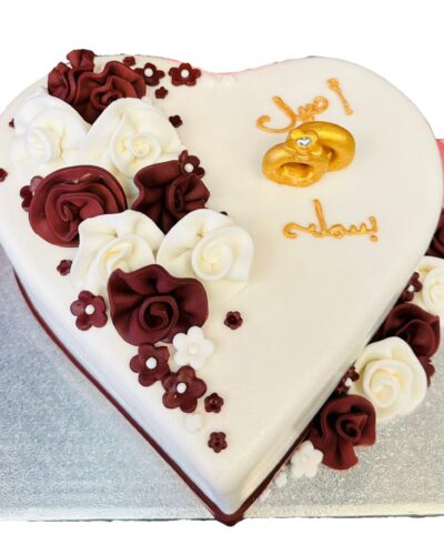 She said yes, gefeliciteerd! Vieringstijd. Wij helpen u een speciale taart te maken, speciaal voor u ontworpen. De taart is hartvormig, waardoor je de liefde ziet stralen! Bovendien is het omgeven door een laagje witte vanille. De gemaakte bloemen worden ook aan de eerste kant van de taart toegevoegd. Op de andere kant van de taart kunnen wij uw naam en de naam van uw partner schrijven in de taal van uw keuze. Bijvoorbeeld Arabisch en Nederlands. Trouwringen werden in het midden toegevoegd om de gelegenheid te vertegenwoordigen. De bloemen die we gemaakt hebben, hebben we ook onderaan de zijkant toegevoegd.